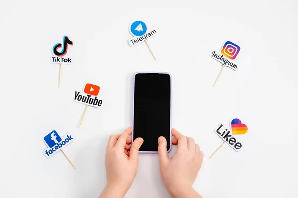 Teens kids social media addiction, detox, fomo. Logos of social networks and messengers Facebook, Instagram, YouTube, Telegram and cell phone in teens kids hand. Kropivnitskiy, Ukraine, May 04, 2021 — Stock Photo, Image