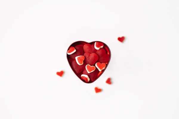 Día de San Valentín, romance, concepto de citas, espacio de copia. Día de San Valentín plano yacía con dulces en forma de corazón rojo en la caja en forma de corazón sobre fondo blanco. — Foto de Stock