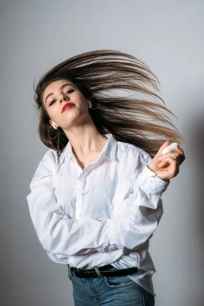 Retrato de estudio de una joven escuchando música en auriculares inalámbricos. Mujer sonriente escuchando música en auriculares —  Fotos de Stock