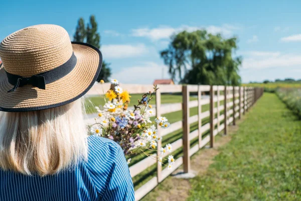 Countryside Getaways, Country vacations, Farm Stays. Young woman in straw hat enjoys summer vacation at the farm in countryside. — Stock Photo, Image