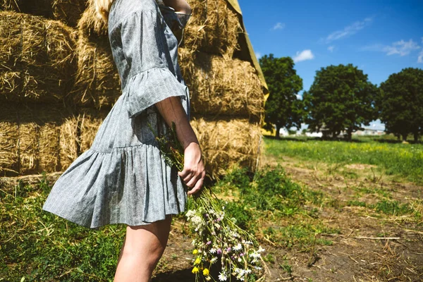 Cottagecore, jednoduché bydlení, venkovský estetický životní styl, moderní venkovská fantazie, pastorální estetika. Mladá dívka v rolnické Cottagecore šaty s wildflowers těší příroda na venkovské farmě — Stock fotografie