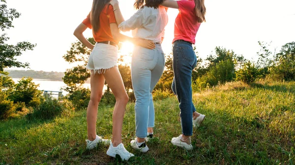 Grupo de amigas saltando al aire libre en la naturaleza puesta del sol. Jóvenes amigos hipsters multiétnicos bailando en la fiesta de verano. Grupo de mujeres amigas abrazando y eyaculando la puesta de sol en la naturaleza al aire libre — Foto de Stock