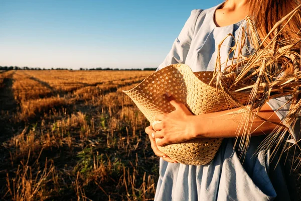 Wanita Ukraina bergaun linen biru dengan spikelet gandum di ladang gandum. Perang di Ukraina mengancam pasokan gandum global — Stok Foto