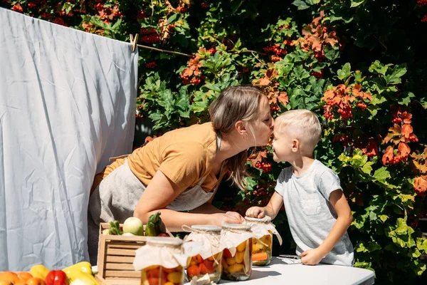 Happy family mother and son kid canning vegetables in the garden in summer day. Canning and Preserve Vegetables From Garden — Stockfoto