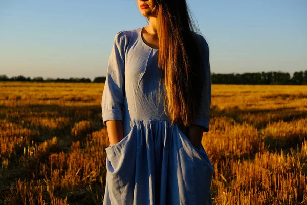 Escapism, getting away from it all, mental health, Stress resilience. Alone Young woman in linen dress walking on mowed wheat field at sunset. Peaceful woman with long hair spending time in nature — 스톡 사진