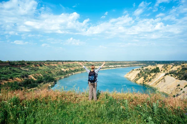 Solo viaggi, viaggi vagabondaggio, vacanze estive, eco turismo, zaino in spalla all'aperto. Turista femminile con zaino in piedi sul bordo della scogliera sul lago — Foto Stock