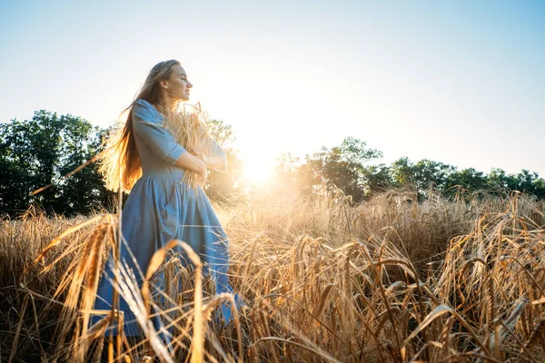 Фізичне та розумове благополуччя. Красива жінка з довгим волоссям насолоджується природою на літньому фоні на заході сонця . — стокове фото