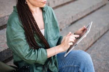 Fazladan para kazanmak, yan işler, para kazanmak, iş ekonomisi, dolandırıcılık, dijital göçebe. Fazladan para kazanmak için ek işler. Dışarıda çalışan dövmeli ve rastalı genç bir kadın.