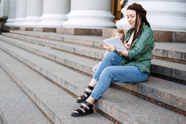 Earn extra money, Side hustle, money making, Gig economy, hustling, digital nomad. Side Jobs to Make Some Extra Money. Young woman, student with tattoo and dreadlocks working outside