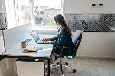 Modern ofiste bilgisayar yazılımı üzerinde çalışan genç bir kadın programcı. Web Tasarımcısı Kadın açık planlama ofisinde masasında çalışıyor.