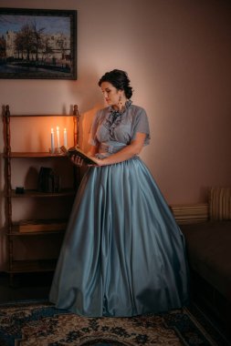 Beautiful woman in blue vintage 1800s early 1900s clothing Cottagecore Edwardian Victorian Epoque dress in old interior. Historical dresses, vintage outfits, beautiful retro dress reconstruction. clipart