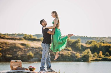 Çiftler için ucuz tatiller, ucuz balayı tasfiyeleri. Samimi bir çift, doğa konusunda el ele tutuşuyor..