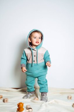 Baby fashion. Unisex clothes for babies. Cute baby in cotton set suit on light background. Kids fashion