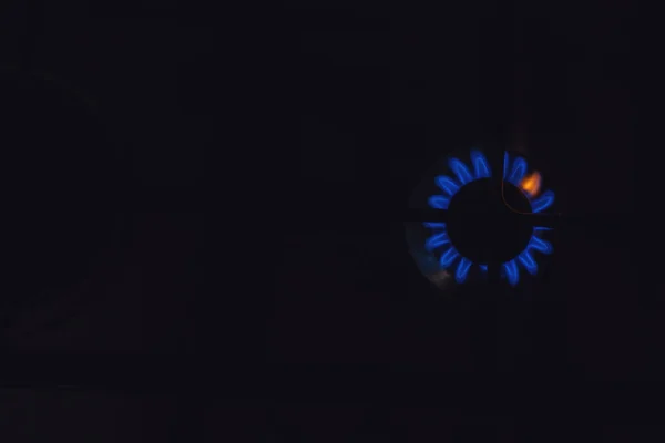 Closeup of blue gas flame on domestic kitchen stove. Gas cooker with burning flames of propane gas in Europe homes. europe dependence from russian gas. Selective focus