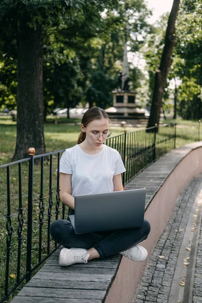 Online jobs for college students. Young woman student girl searching job with laptop outdoors in summer day. Side hustle for students