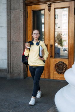Student loan, Student finance for undergraduates. Outdoor portrait of happy student girl with laptop, papers and books near college, university