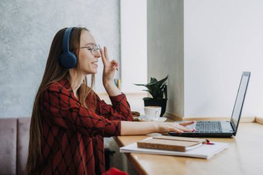 Freelancing for beginners, working as freelancer, Flexible working hours. Young candid woman freelancer working with laptop and documents in cafe, coworking workplace