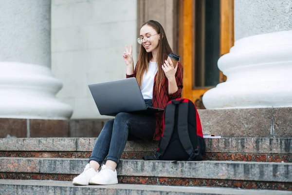 Online tutor, tutoring jobs for college students. How earn extra money while learning. Side hustling for students. Outdoor portrait of student girl with laptop having video call