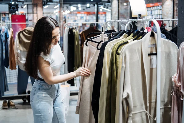 Second hand. Sustainable fashion. Young Latina woman buying used sustainable clothes from second hand shop