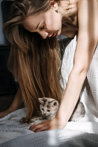 Mindfulness, How to Live in the Moment, Be More Present. Being in the present moment, here and now. Young woman play with kitten at home in morning