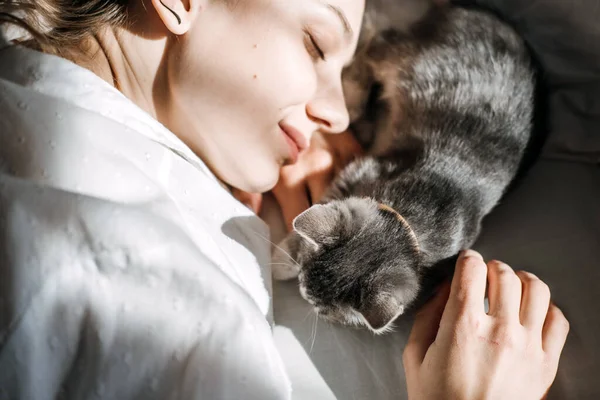 Mindfulness, How to Live in the Moment, Be More Present. Being in the present moment, here and now. Young woman play with kitten at home in morning