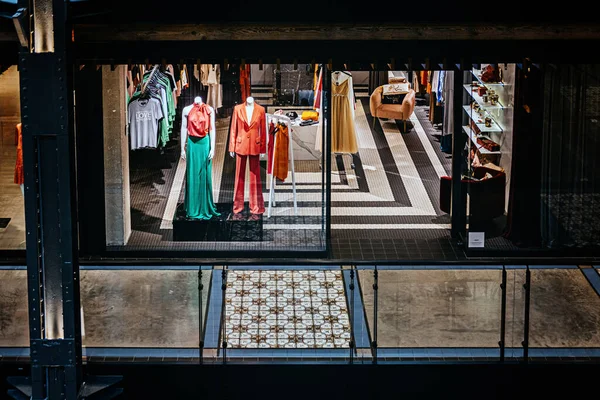 Boutique window with clothing, shoes, bags and mannequin in big mall, shopping center. Boutique window with dressed mannequins