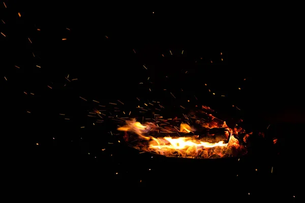 Campfire flame sparks isolated on black background. Fire flames heat energy heap in the night. Fire sparkles isolated on black background