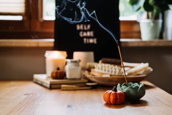 Self-care, Wellness in autumn, winter cold season. Letter board text Self Care Time, aroma sticks, body and self-care handmade cosmetics and beauty product and decor pumpkins.