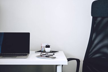 Dijital iş fikirleri. Çevrimiçi İş. Boş ekran dizüstü bilgisayarı, cep telefonu, kalem, beyaz çalışma masasında modern çalışma alanı.