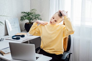 İşteyken egzersiz. Ofis Egzersizleri, Ofiste Sağlıklı Kalmak İçin Çalışma Masası Egzersizleri. İş yerindeki genç bayan ofis çalışanı ellerini ve vücudunu uzatarak işe ara veriyor..