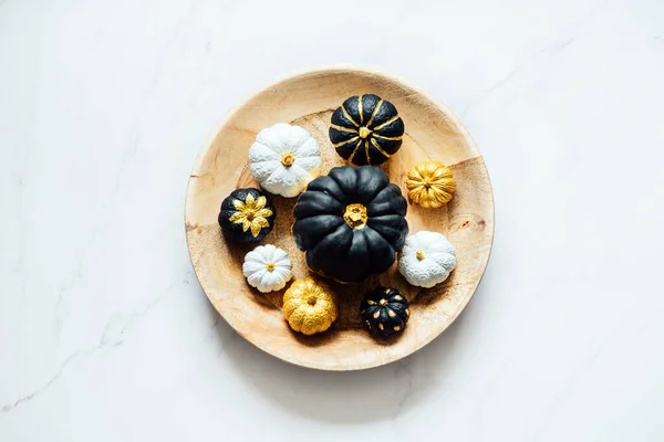 ハロウィンと感謝祭のためのブラックゴールドホワイトカボチャ ミニマルトップビュー丸皿に黒黄金のトレンディーなカボチャを描くとフラットレイアウト秋の組成 — ストック写真