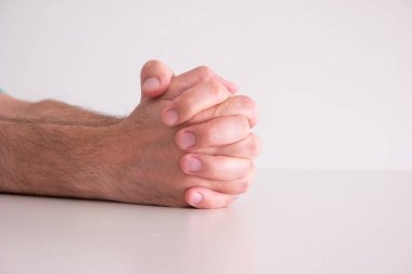 Beyaz arka planda izole edilmiş beyaz erkek elleri dua ederken birbirine yapışmış..