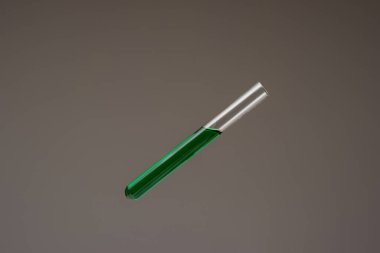 Cam test tüpünde yeşil renkli sıvı. Stüdyo çekimini kapat, gri arka planda izole edilmiş, insan yok..