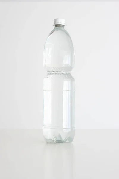大的透明塑料水瓶 白帽密闭 垂直演播室拍摄 被白色隔离 没有人 — 图库照片