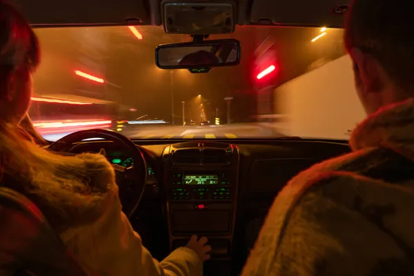 夜の車の運転 車のビューの中で 白人女性ドライバーと男性の乗客は 両方とも認識できない 光の外では ショット 長い露出を移動します 照光式ダッシュボード — ストック写真