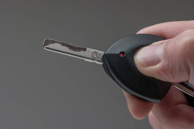 Beyaz bir erkek, arabanın anahtarlığını tutuyor. Stüdyo makro çekimini kapat..