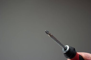 Tornavidayı adamın eline ver. Stüdyo çekimini kapat, gri arkaplanda izole edilmiş..