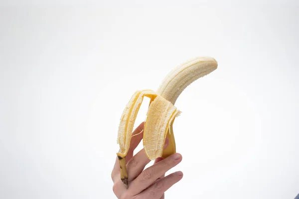Спелый Желтый Полуочищенный Банан Прижатый Руке Белой Мужской Рукой Закрыть — стоковое фото