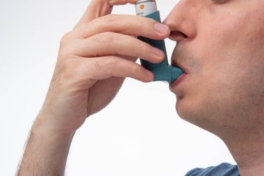 Astım spreyi, jenerik, markasız, tanınmayan insanlar tarafından kullanılıyor. Stüdyo çekimini kapat, beyaz arkaplanda izole edilmiş..