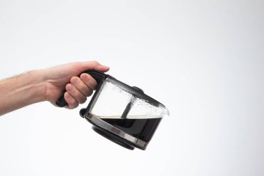 Ev yapımı büyük cam kahve demliği, bir adamın bardaktan boşalırcasına el ele tutuşması. Stüdyo çekimini kapat, beyaz arkaplanda izole edilmiş..