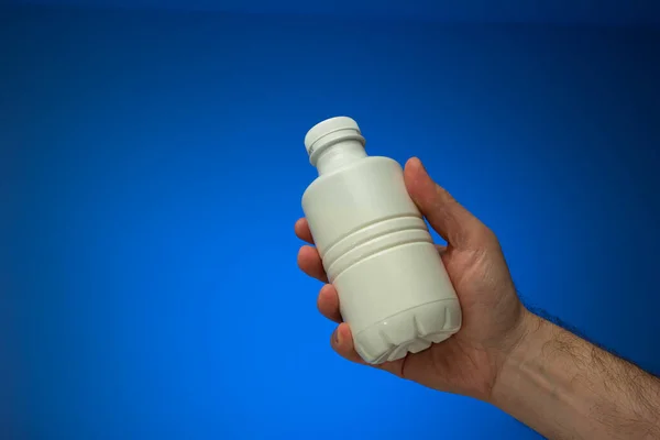 White Opaque Plastic Bottle Held Hand Caucasian Male Close Studio — Fotografia de Stock