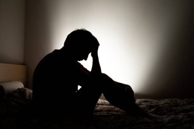 Erkek silueti, dairesinde oturan yalnızlığı ya da depresyonu tasvir ediyor..