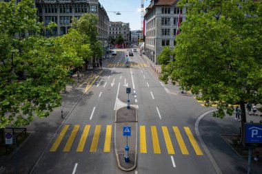 İsviçre 'nin Zürih şehrinde sarı bir zebra yaya geçidi. Düşük trafik, yüksek görüş açısı, güneşli yaz günü, historik şehir merkezi..
