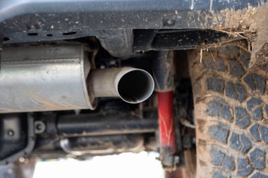 SUV car exhaust muffler or resonator and tip. Low angle view, no people. clipart