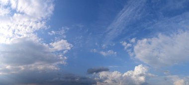Rahatsız edici bulutluluk, açık, soğuk ve karanlık tonlarda mavi bir gökyüzüne karşı çeşitlilik. Atmosferik bir fenomenin panoramik fotoğrafı, buhar halinde su parçacıklarının konsantrasyonu.