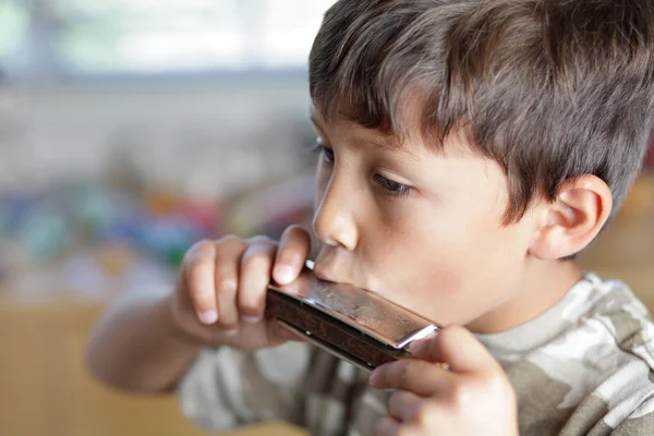 Junge spielt mit Mundharmonika — Stockfoto