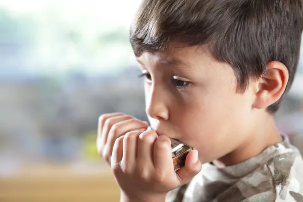 Мальчик с губной гармошкой — стоковое фото
