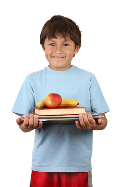 Школьник с фруктами и книгами — стоковое фото