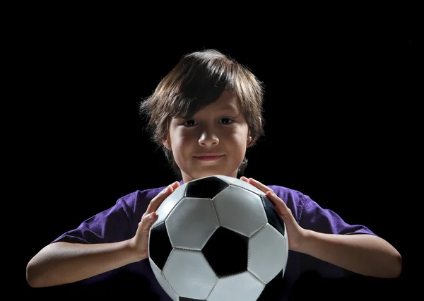 Gutt med fotball på mørk bakgrunn – stockfoto