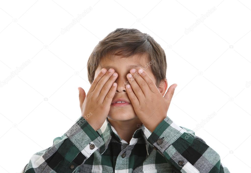 Young boy covers his eyes